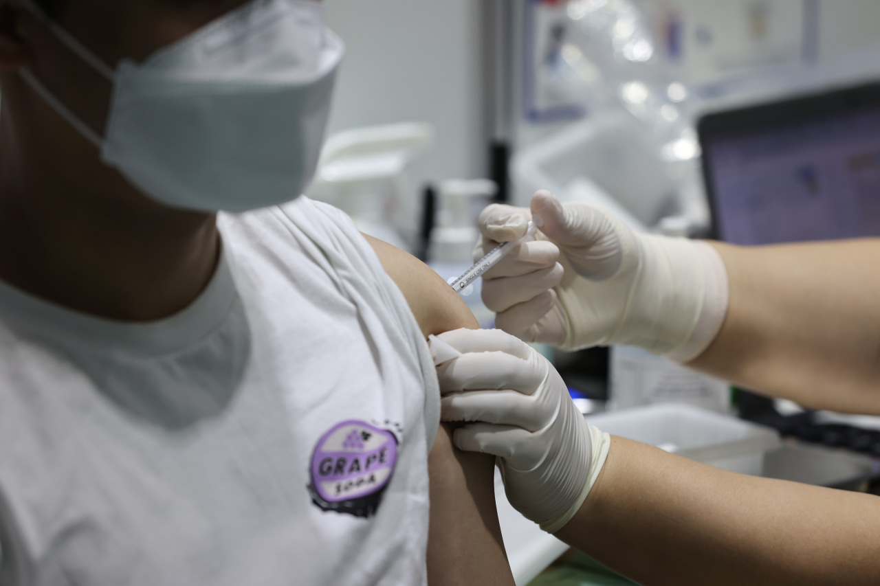 This photo, taken Tuesday, shows a health worker administering a COVID-19 vaccine shot at a state-run inoculation center in western Seoul. (Yonhap)