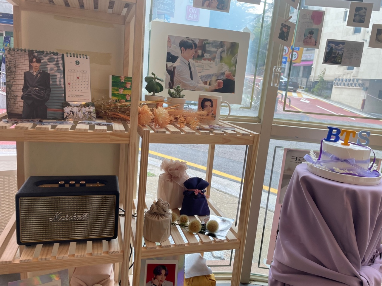 Exclusive goodies, such as the calendar and the mug, are exhibited on the shelving unit and the wall to celebrate Jung-kook’s birthday. (Kweon Ha-bin/The Korea Herald)