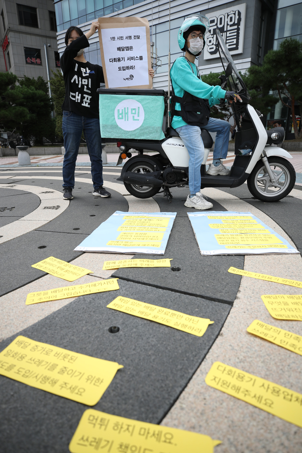 Green Korea and Riders Union hold press conference to call on food delivery platforms to introduce the option of reusable containers in front of Baedal Minjok headquarters in Seoul on Thursday. (Yonhap)