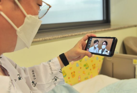 A patient at Yonsei University‘s Severance Hospital speaks to doctors via a smartphone. (Severance Hospital)