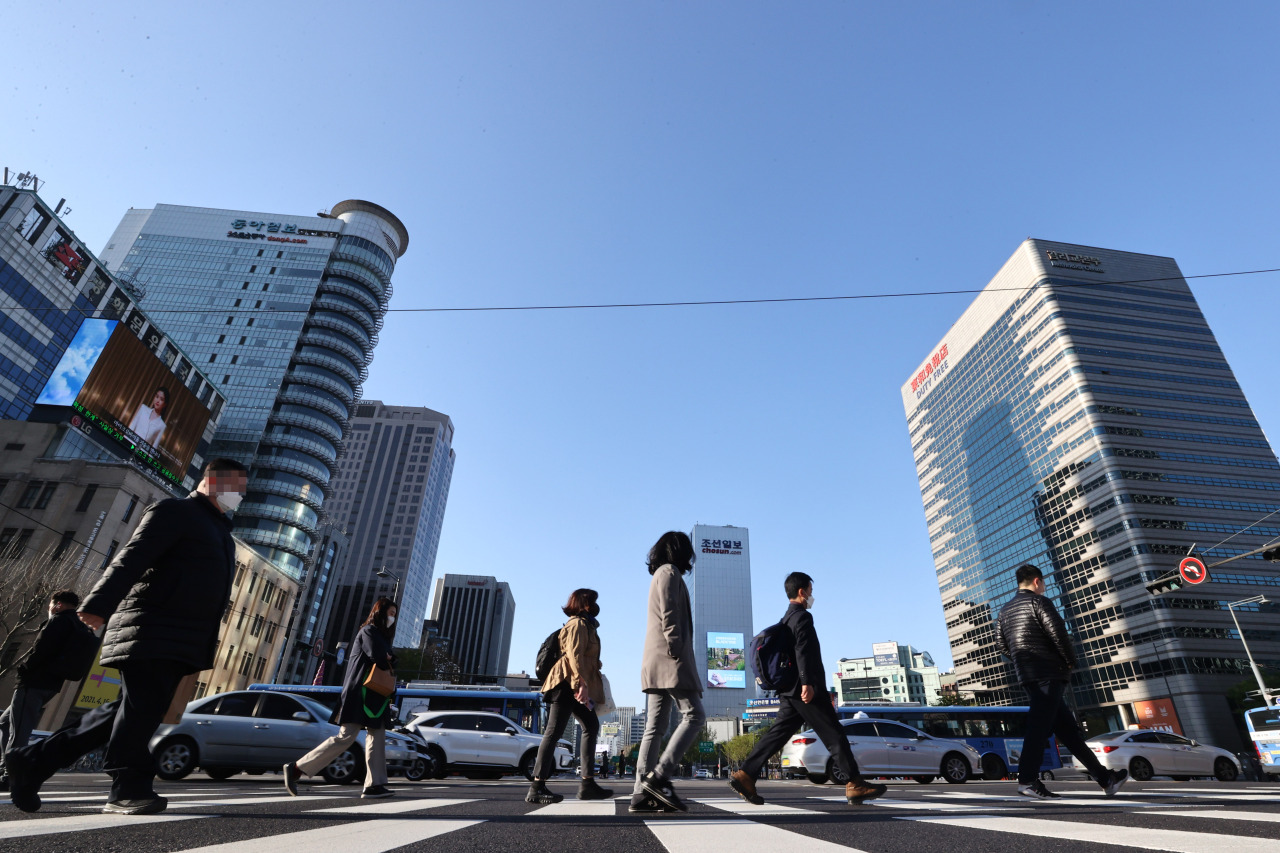 People cross the street near Gwanghwamun Square, central Seoul (Yonhap)