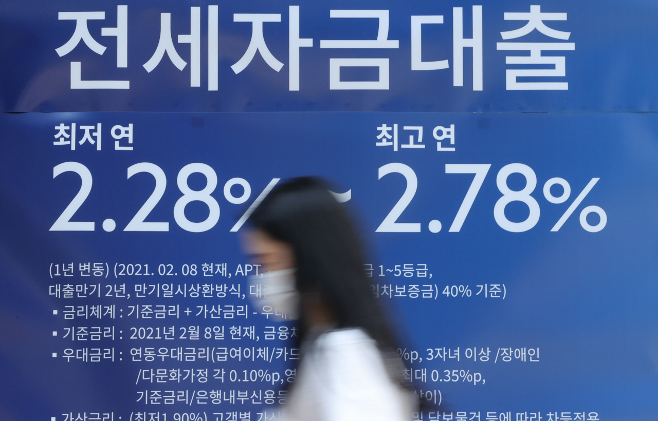A pedestrian passes by a commercial bank promoting jeonse loan in Seoul on Thursday. (Yonhap)