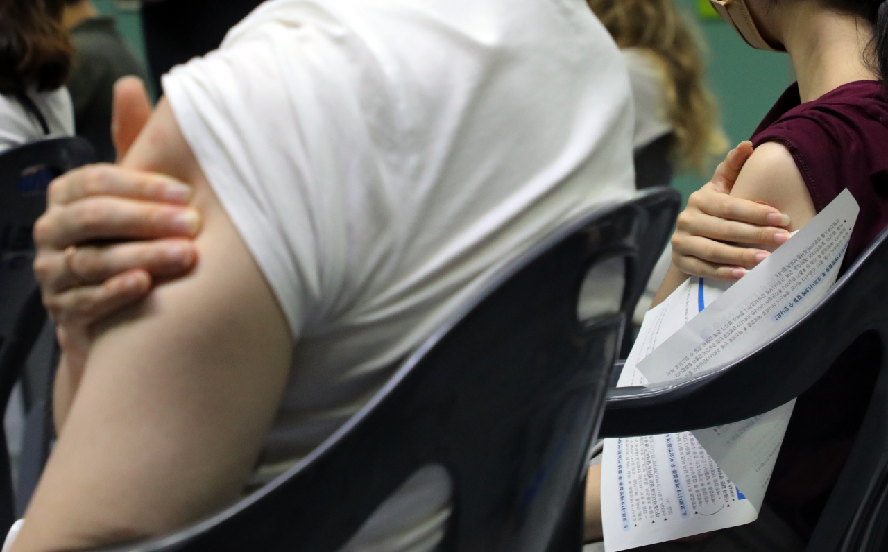 This photo taken Tuesday shows the arms of freshly vaccinated people at a Seoul vaccination clinic. (Yonhap)