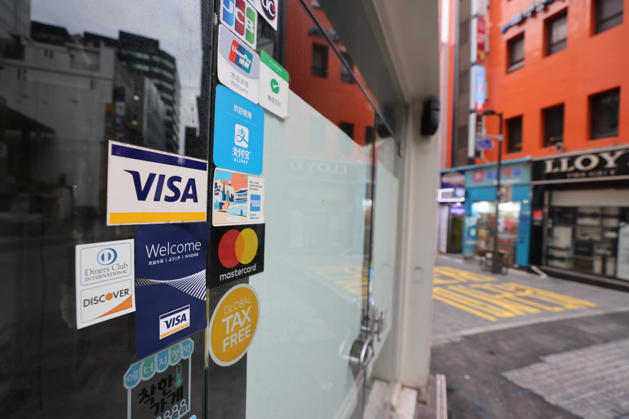 Credit card signs are attached on the door of a closed store in Myeongdong, Seoul on Sep. 27. (Yonhap)