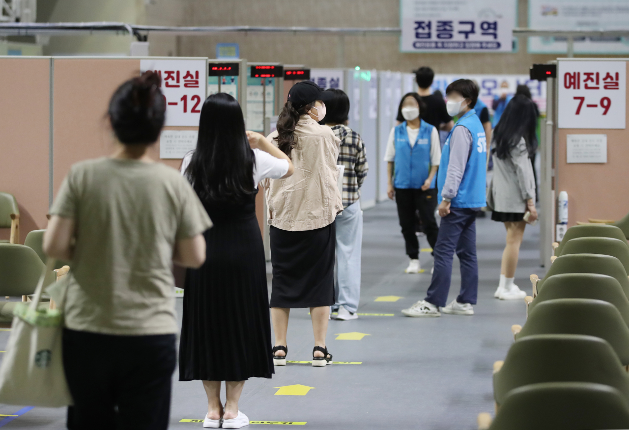 People wait for COVID-19 jabs at a vaccination center in western Seoul on Tuesday. (Yonhap)