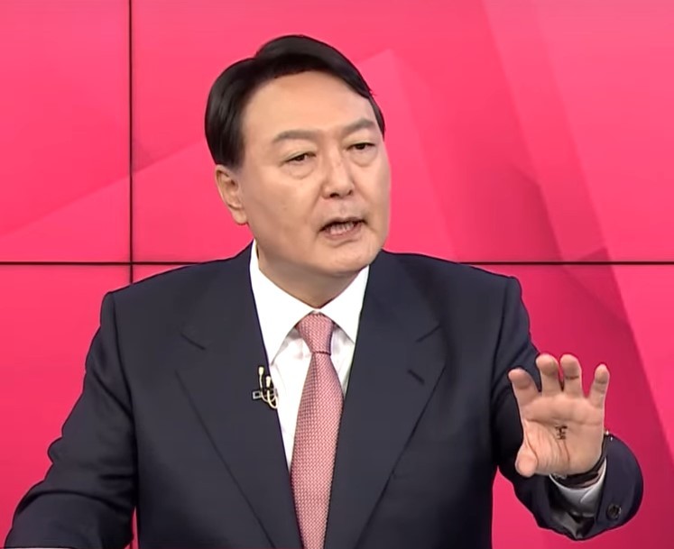 The Chinese character meaning “king” can be seen on the palm of Former Prosecutor General Yoon Seok-youl’s left hand during a televised debate Friday. (Screenshot of MBN News YouTube channel)