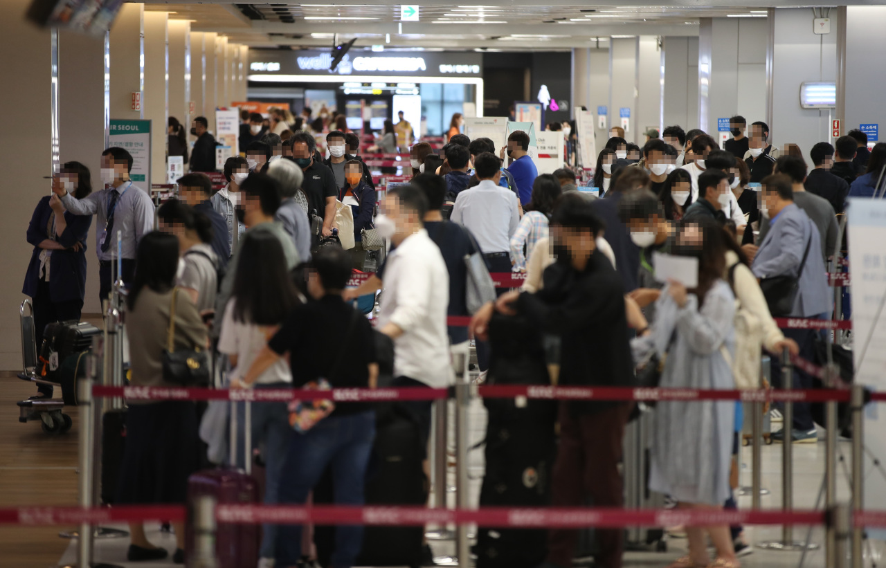 This photo taken on Friday shows people waiting at ticketing counters at Gimpo International Airport in western Seoul ahead of an extended weekend that includes Hangeul day. (Yonhap)