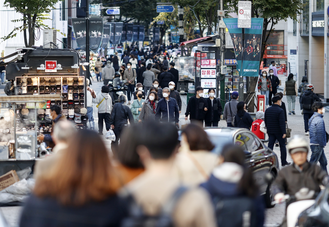 Masked citizens roam the streets of Myeong-dong, a popular tourist district in central Seoul, on Sunday. (Yonhap)