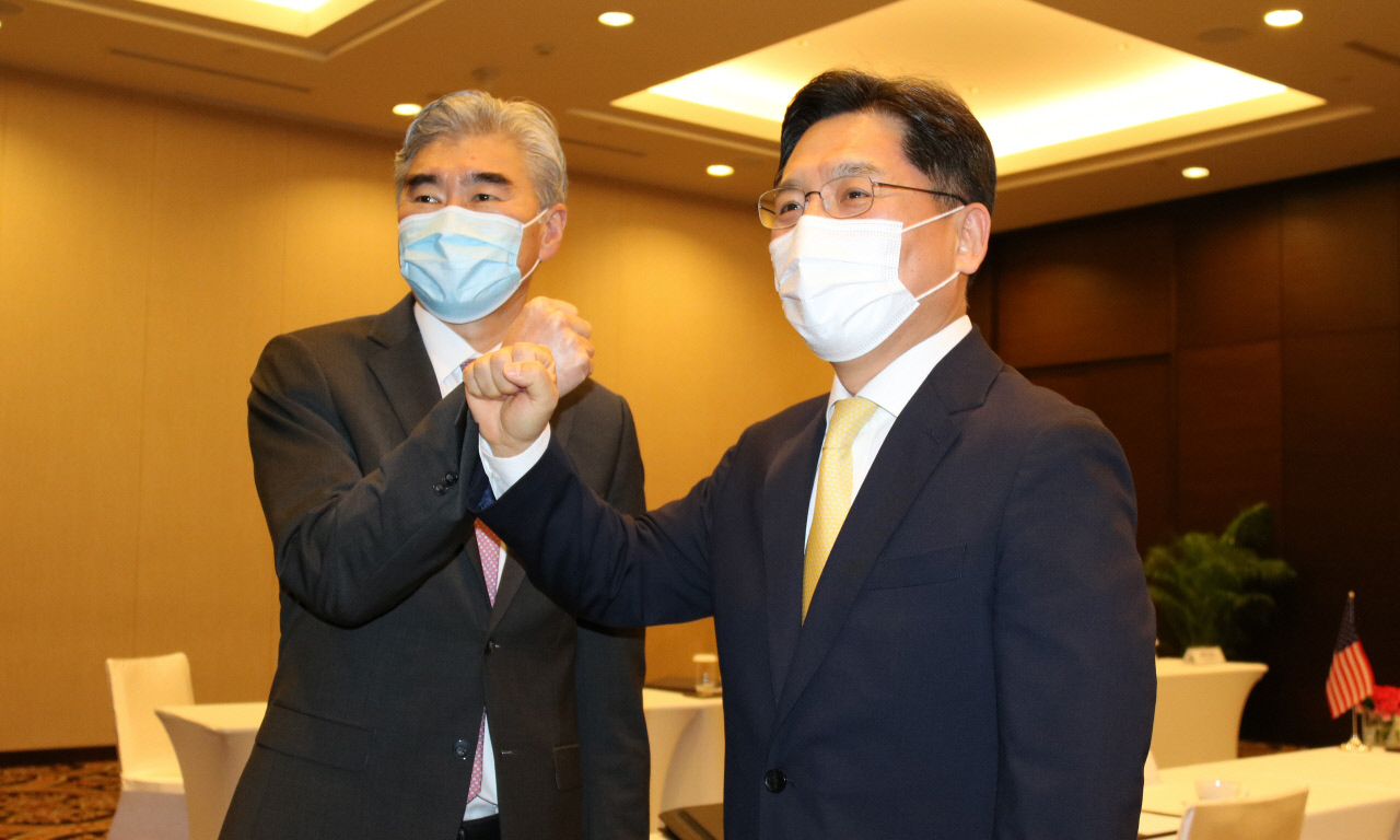 Noh Kyu-Duk (R), special representative for Korean Peninsula peace and security affairs, fist-bumps Sung Kim, US special representative for North Korea policy, before their meeting at a hotel in Jakarta, Indonesia, in this file photo taken Sept. 30, 2021. (Yonhap)