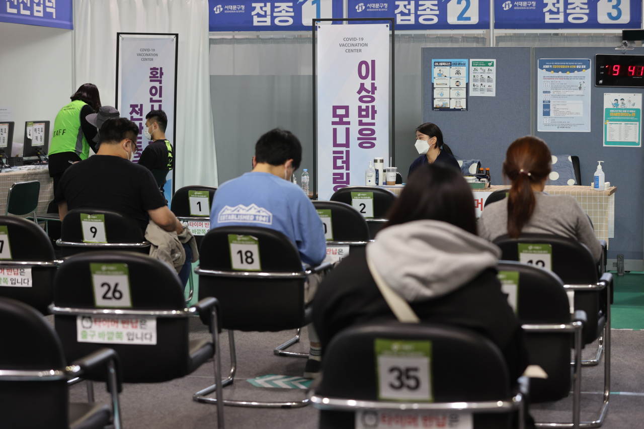 People wait to check for any abnormal symptoms after getting vaccinated against COVID-19 at an inoculation center in Seoul on Thursday. (Yonhap)