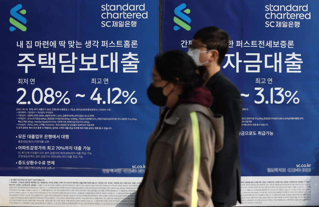 Pedestrians pass by a commercial bank promoting jeonse and mortgage loans. (Yonhap)