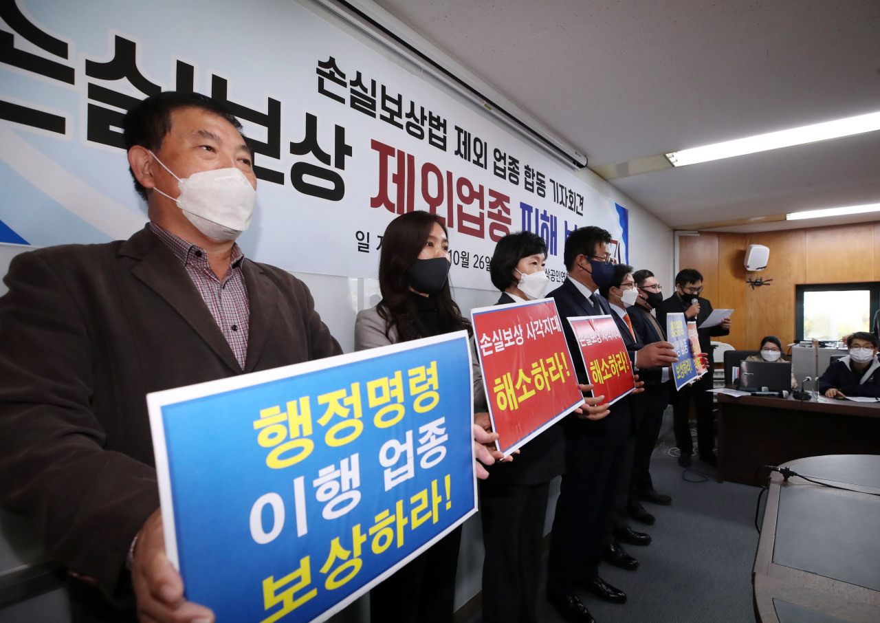 Business owners who were excluded from the subsidy program urge the government to expand it, at a press conference in Yeouido, western Seoul, Tuesday. (Yonhap)