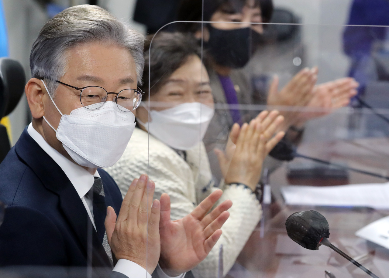 Lee Jae-myung, the presidential nominee of the ruling Democratic Party (DP) claps during his party's meeting in Seoul on Friday. (Yonhap)