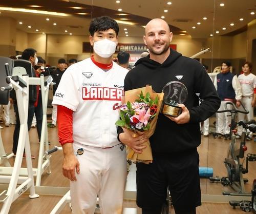 Jamie Romak of the SSG Landers (R) poses for pictures with the club captain Lee Jae-won during Romak's retirement ceremony inside the clubhouse at Incheon SSG Landers Field in Incheon, 40 kilometers west of Seoul, on Saturday. (SSG Landers)