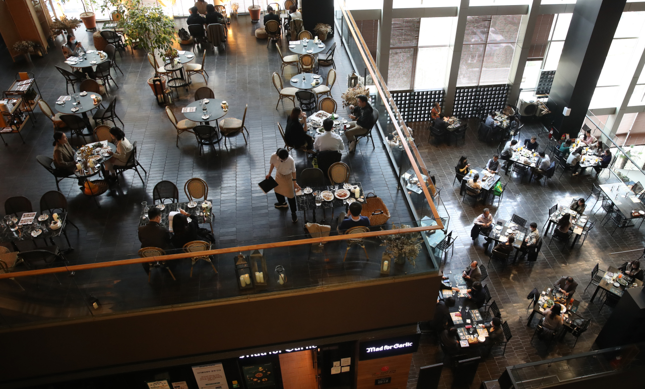 People eat lunch at a restaurant in central Seoul on Monday, when the first phase of “living with COVID-19” began. (Yonhap)