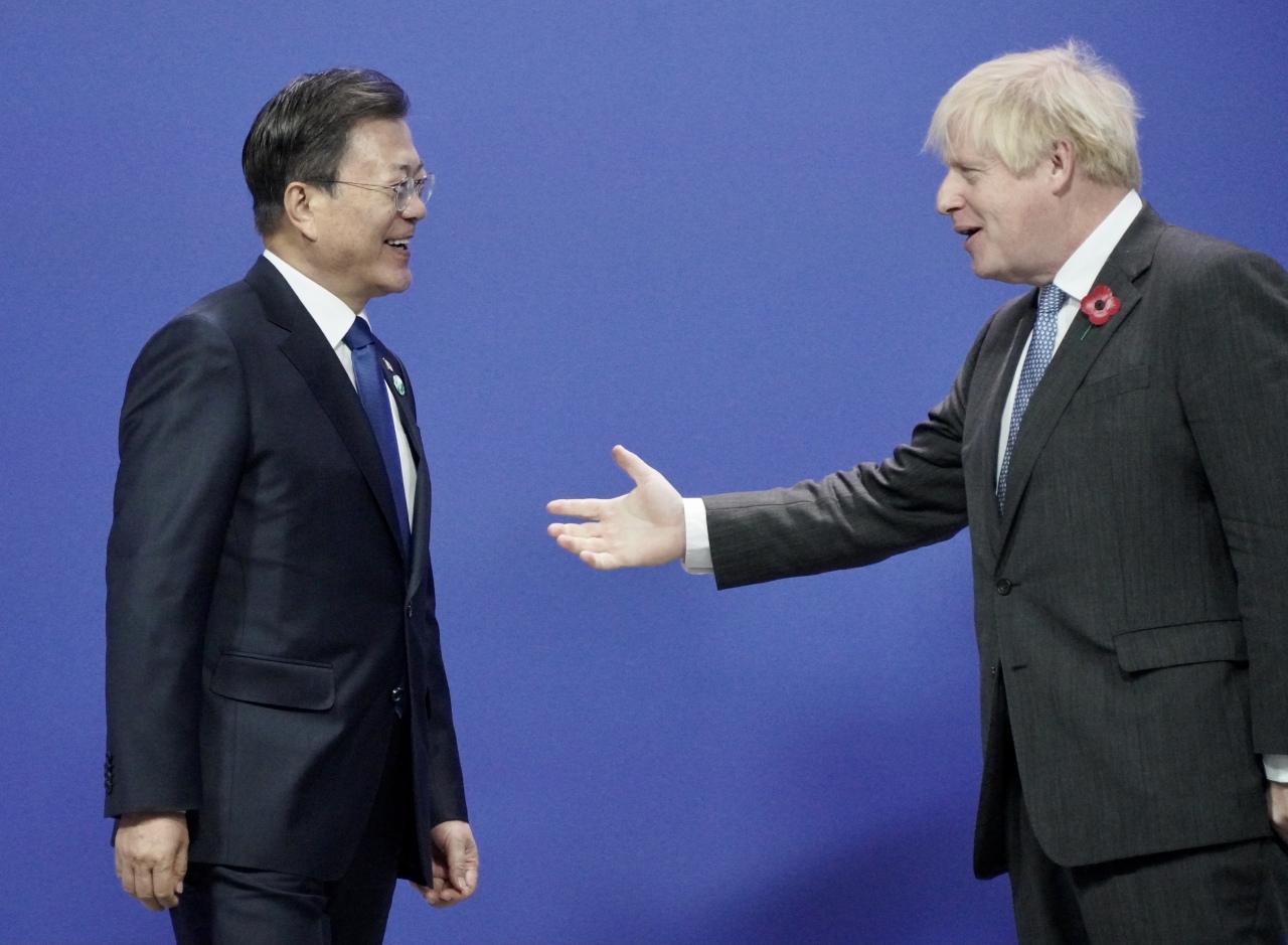 President Moon Jae-in is greeted by British Prime Minister Boris Johnson upon his arrival at the COP26 UN Climate Summit in Glasgow, Scotland, Monday. (Yonhap)