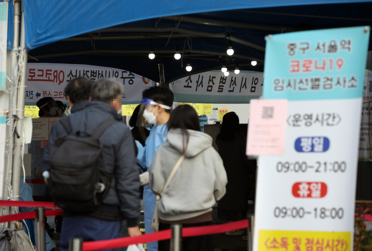 People wait in line to get tested for COVID-19 at a makeshift clinic in central Seoul on Tuesday. (Yonhap)