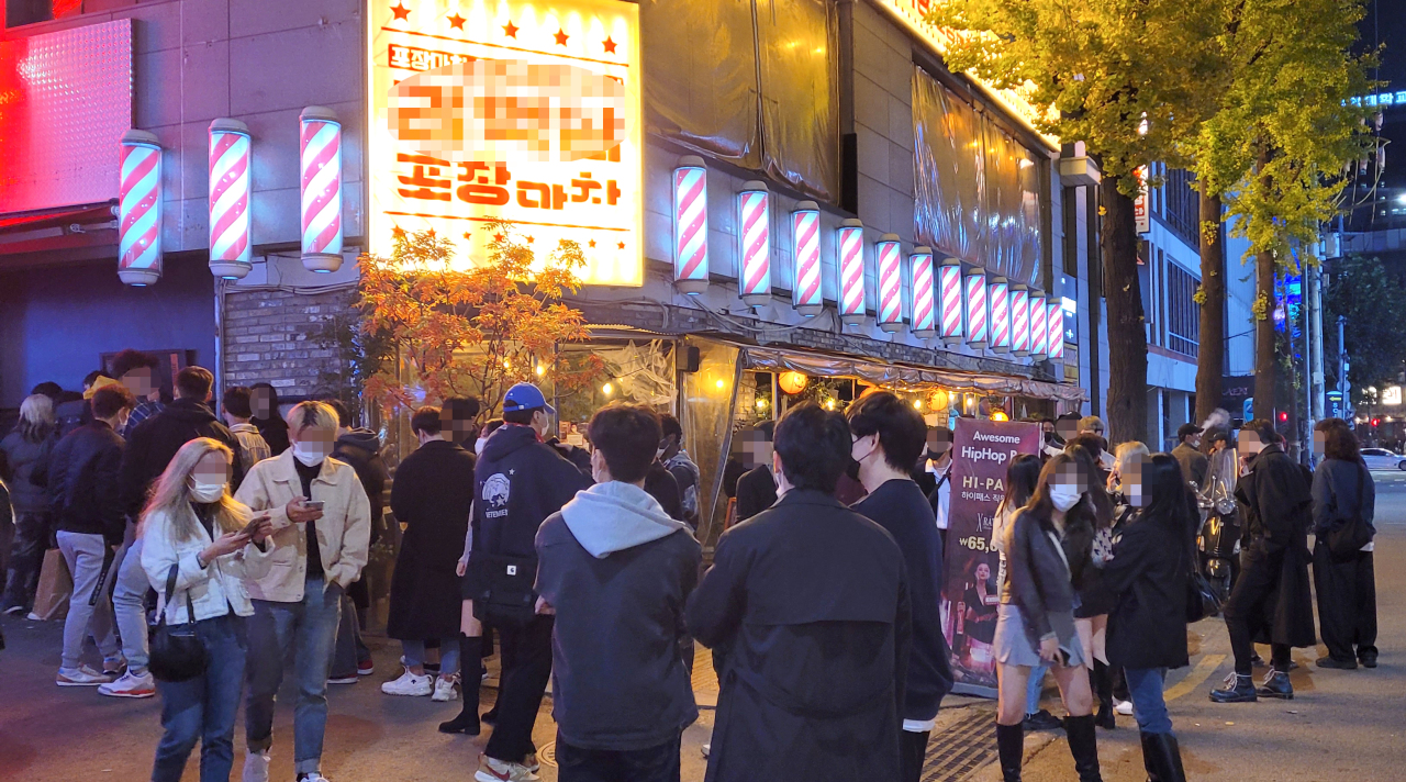The streets of Hongdae in Mapo-gu, western Seoul, are bustling with people on Monday night. Earlier in the day, nighttime curfews on bars and restaurants were lifted as part of the government’s plan for “living with COVID-19.” (Yonhap)