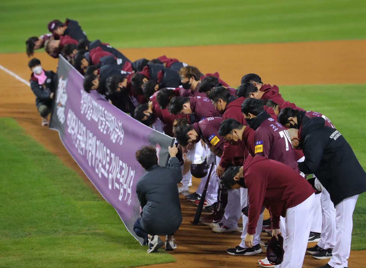 Members of the Kiwoom Heroes bow their heads before a section of their fans at Jamsil Baseball Stadium in Seoul on Tuesday, after losing to the Doosan Bears 16-8 in the second wild card game in the Korea Baseball Organization postseason. (Yonhap)