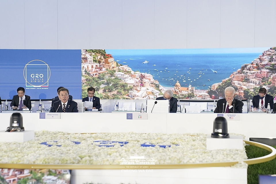 South Korean President Moon Jae-in (L) sits next to US President Joe Biden during a session of the Group of 20 major economies in Rome on Sunday, to address pandemic-induced disruptions in supply chains. (Yonhap)