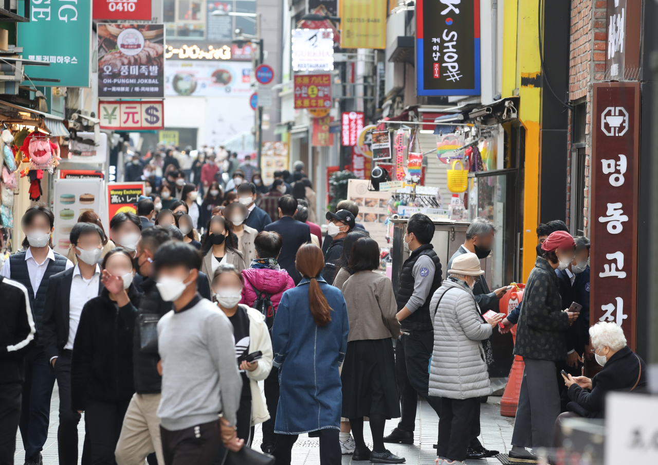 The shopping district of Myeongdong in Seoul bustles with people during lunchtime last Monday, the first day of the introduction of the eased social distancing 