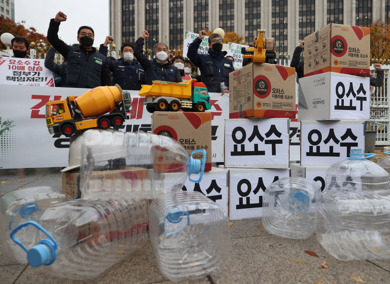 Unionized construction workers urge the government to resolve the urea water solution shortage crisis during a news conference held in front of the government complex in central Seoul on Tuesday. (Yonhap)