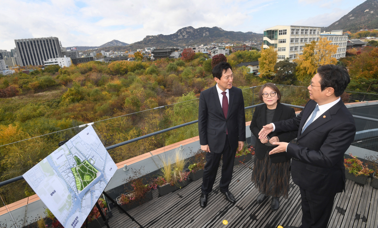 (From left) Seoul Mayor Oh Se-hoon talks with Kim Young-na, the head of an expert panel formed to make decisions about a new hall to house the late Lee Kun-hee’s art collection, and Culture Minister Hwang Hee on the rooftop of the Seoul Museum of Craft Art in Jongno-gu, central Seoul, Wednesday. The rooftop overlooks the site of the new hall. (Yonhap)