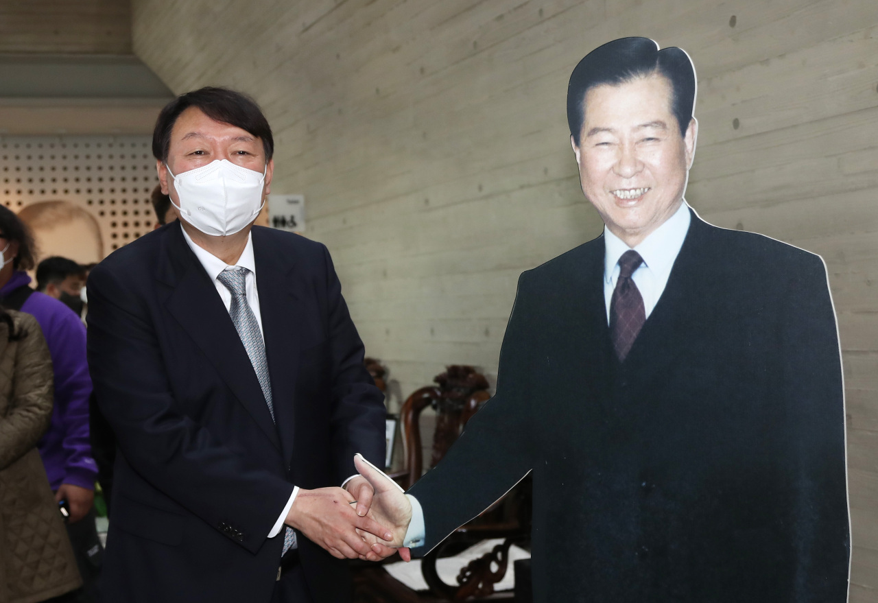 Yoon Seok-youl, the presidential nominee of the main opposition People Power Party, holds the hand of a cutout of late former President Kim Dae-jung at the Kim Dae Jung Nobel Peace Prize Memorial in the southwestern city of Mokpo on Thursday. (Yonhap)
