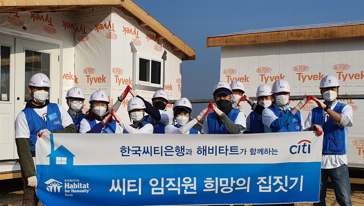 Citibank Korea employees and members of Habitat for Humanity Korea pose for a photo during the bank’s “Citi Building Hope and Home” volunteering program aimed at building homes for the underprivileged, on Nov.3, in Cheonan, South Chungcheong Province. (Citibank Korea)