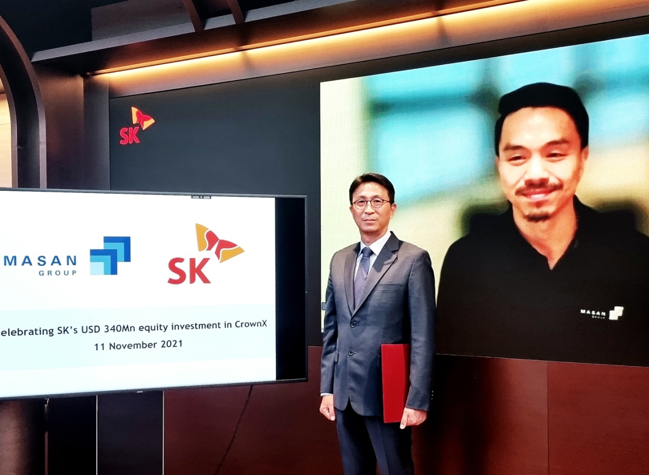 Managing Director Park Won-cheol of SK South East Asia Investment (left) poses with Masan Group CEO Danny Lee after signing an investment deal online at SK Group’s office in Jongno, central Seoul, Thursday. (SK Group)