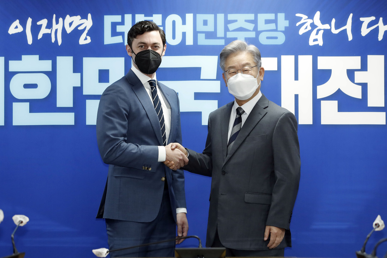 Lee Jae-myung (R), the presidential candidate of the ruling Democratic Party (DP), shakes hands with US senator Jon Ossoff at his party's headquarters in Seoul on Friday. (Yonhap)