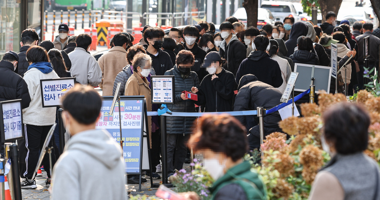 People line up to take coronavirus tests outside a public health center in Seoul on Sunday. (Yonhap)