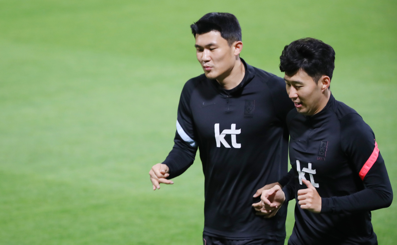 Kim Min-jae (L) and Son Heung-min of the South Korean men's national football team train at Al-Sailiya Sports Club in Doha on Sunday, in preparation for a World Cup qualifying match against Iraq. (Yonhap)