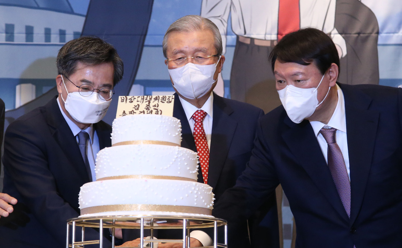 Kim Chong-in (center) and People Power Party`s presidential nominee Yoon Seok-youl (right) cut a congratulatory cake at a book event on Kim held Monday in Yongsan-gu, central Seoul. (Joint Press Corps)