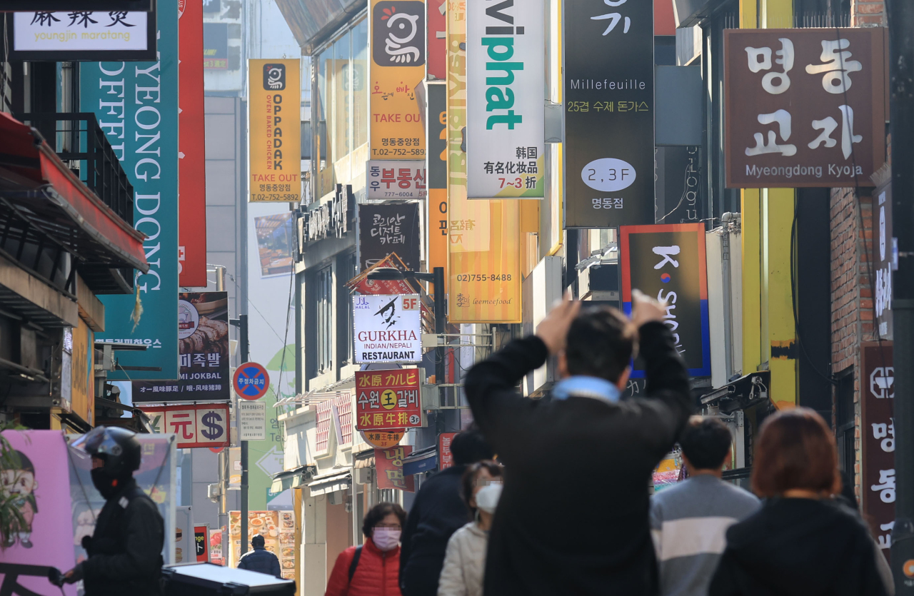 People walk on a street filled with restaurants. (Yonhap)