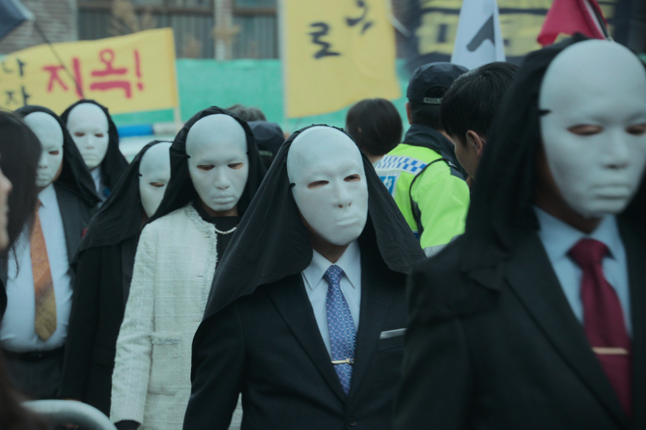 The masked members of New Truth in “Hellbound.” (Netflix)
