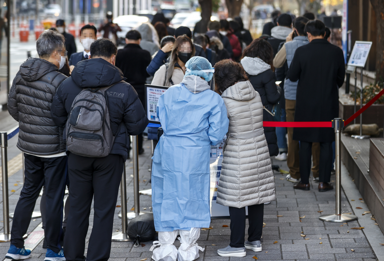 People stand in line to receive coronavirus tests at a screening clinic in southeastern Seoul on Wednesday. (Yonhap)