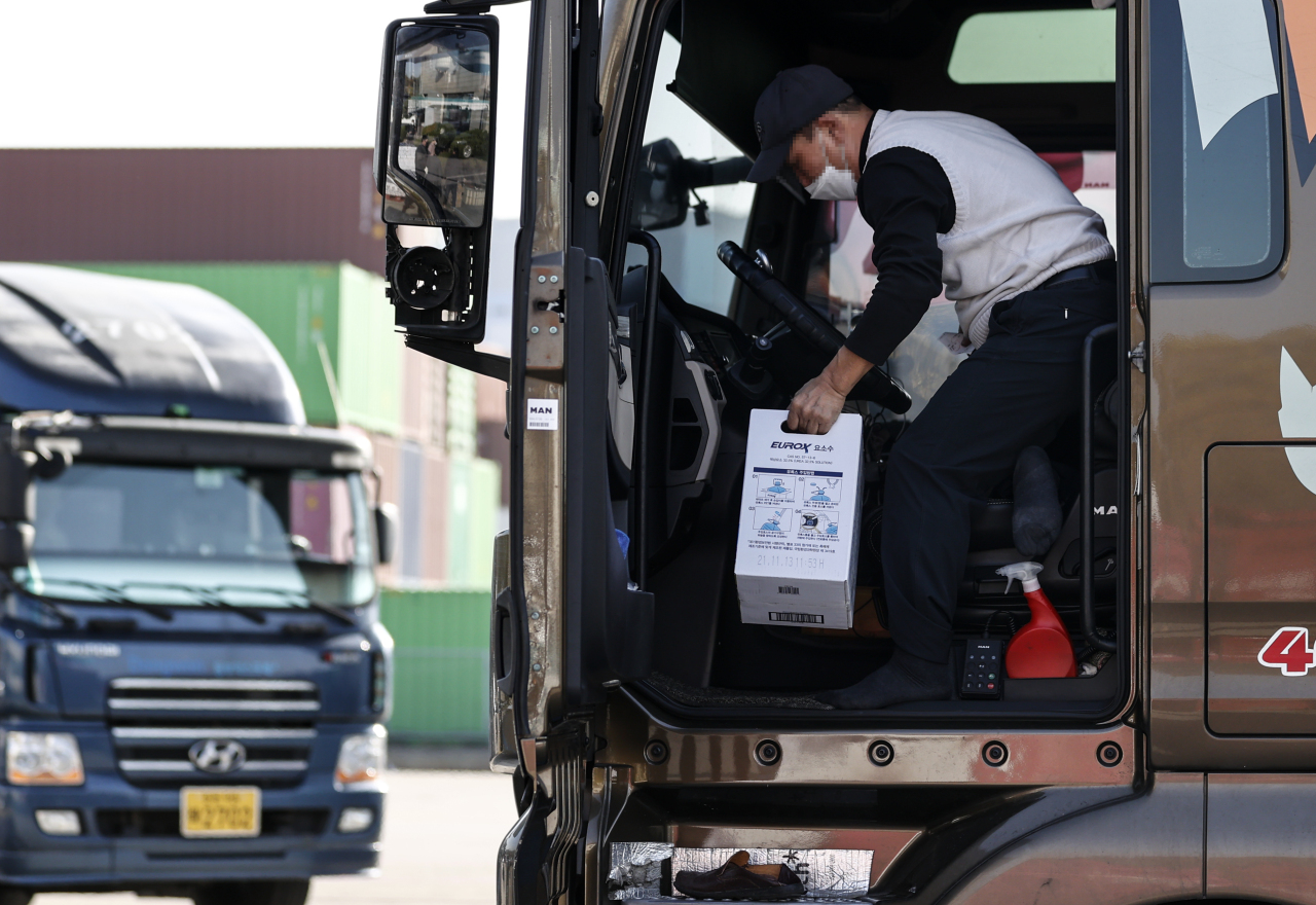 A truck driver loads a box of urea solution, which is needed in diesel vehicles to cut emissions, at a gas station in Uiwang, south of Seoul, on Tuesday. (Yonhap)