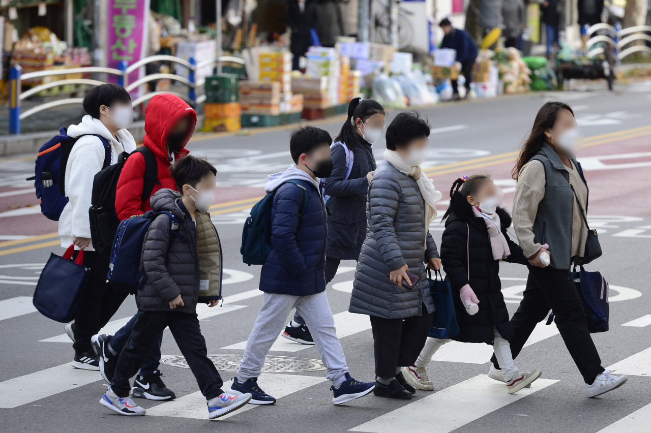 Students head to in-person classes at an elementary school in Seoul's Yongsan district on the first day of the full resumption of in-person school attendance on Monday. (Yonhap)