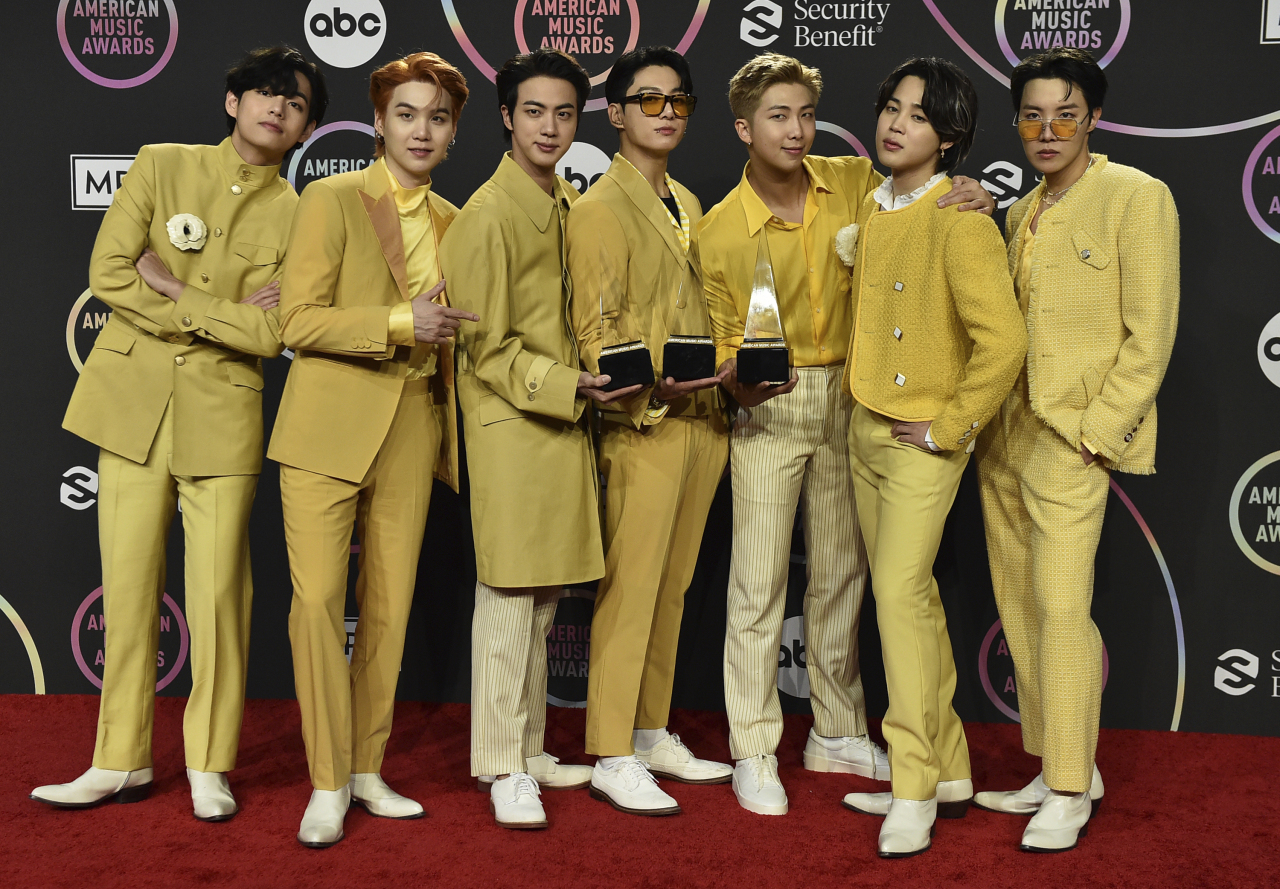 K-pop boy group BTS poses with the awards for favorite pop duo or group, favorite pop song for “Butter,” and artist of the year at the American Music Awards on Sunday (US time) at Microsoft Theater in Los Angeles. (AP-Yonhap)