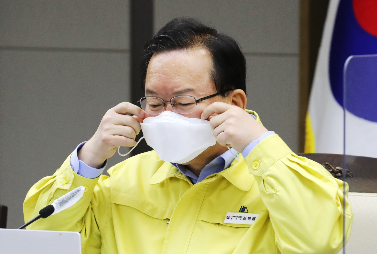 Prime Minister Kim Boo-kyum puts on his mask during a COVID-19 response meeting in Sejong on Wednesday. (Yonhap)