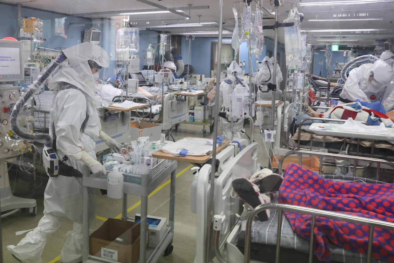 Medical workers in full protective gear care for COVID-19 patients at an intensive care unit of a COVID-only hospital in Pyeongtaek, 70 kilometers south of Seoul, on Tuesday. The operating ratio of beds for critical patients in the metropolitan areas had reached 83.3 percent as of 5 p.m. the previous day, an all-time high. (Yonhap)