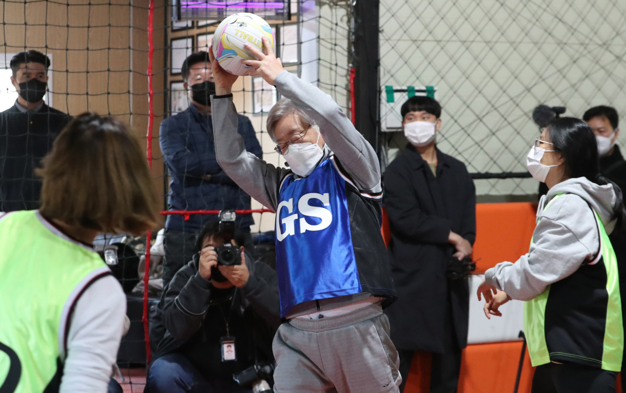 Lee Jae-myung, presidential nominee for the ruling Democratic Party of Korea, plays netball with female voters in their 20s as a part of his campaign event in Goyang, Gyeonggi Province, on Oct. 31. (Joint Press Corps)