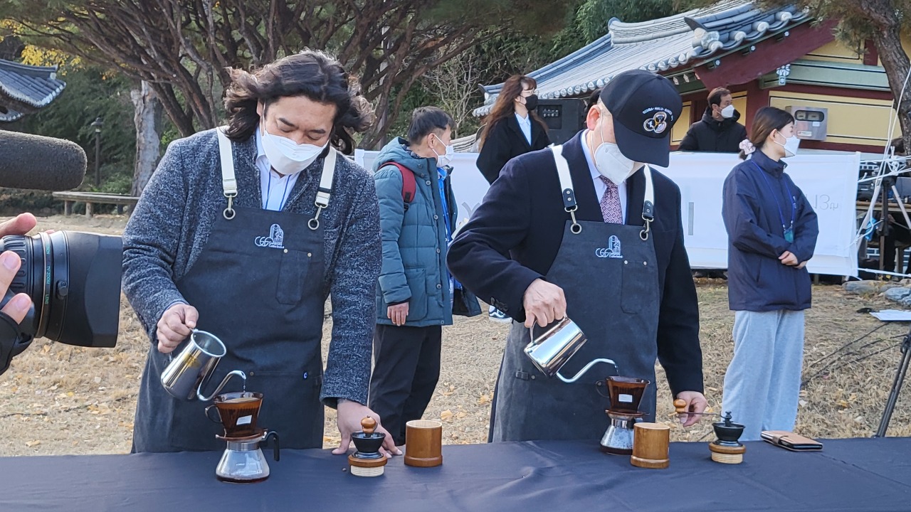 Yang Jin-ho (left), president of the Gangneung Coffee Festival’s executive committee, makes coffee during the “100 People 100 Tastes” performance on Saturday. (Kim Hae-yeon/The Korea Herald)
