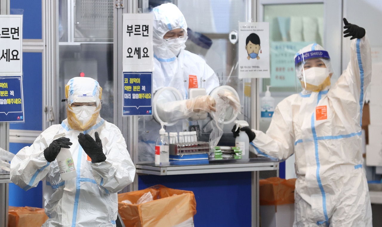 Medical workers carry out their job at a COVID-19 testing booth at a public health center in Seoul's southeastern district of Songpa on Sunday. (Yonhap)
