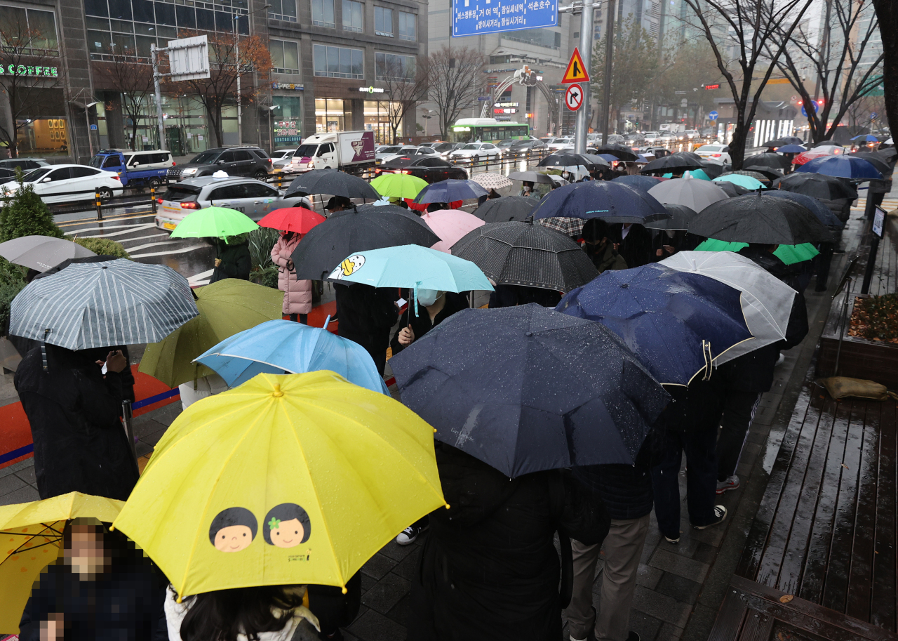 People wait in a line to take coronavirus tests at a screening station in Songpa Ward, southern Seoul, on Tuesday. (Yonhap)