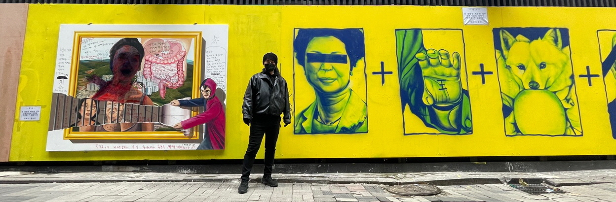 Graffiti artist Ninbolt stands in front of the wall of a secondhand book store on which he has depicted political scandals of Yoon Suk-yeol, the presidential candidate of the main opposition People Power Party. (Park Ga-young/The Korea Herald)