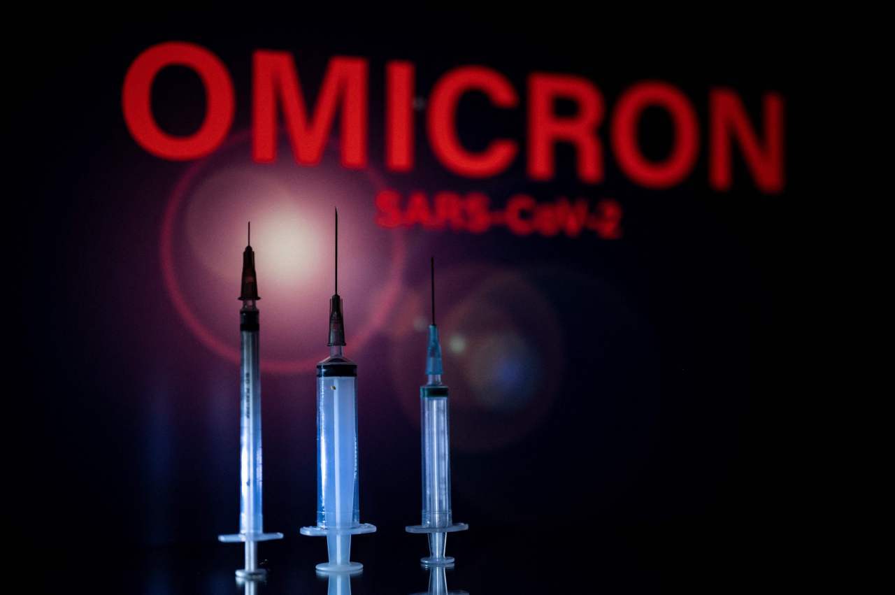 This photograph taken on Wednesday shows syringes and a screen displaying Omicron, the name of the new covid 19 variant in Toulouse, southwestern France.(AFP)