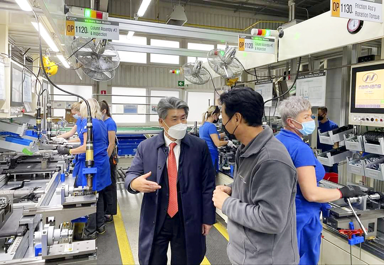 IBK CEO Yoon Jong-won talks with a Namyang Nexmo official at the auto parts manufacturer’s factory in Katowice, Poland on Nov. 26. (Industrial Bank of Korea)