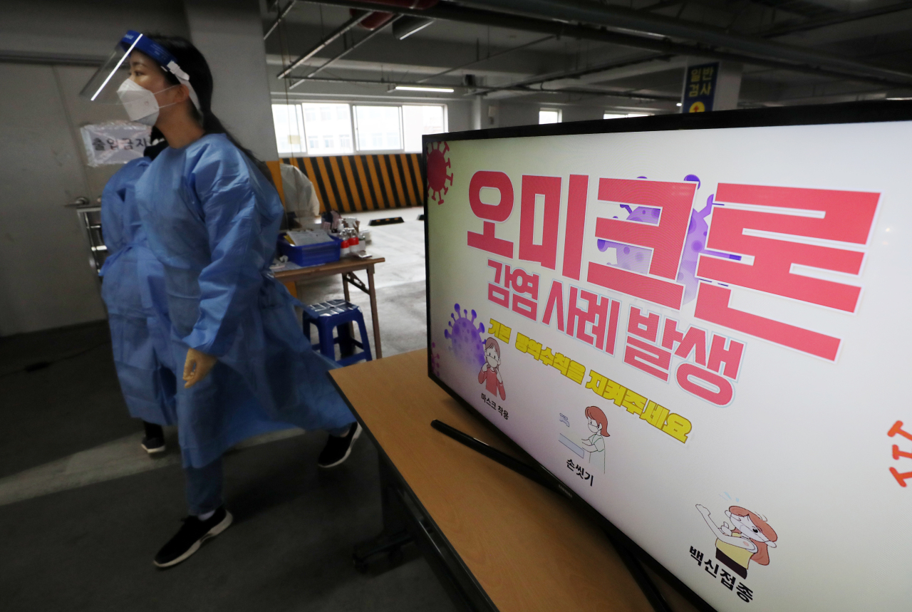 A screen at a screening center for coronavirus tests in the southwestern city of Gwangju on Friday shows a report on the emergence of South Korea`s first cases of the new omicron coronavirus variant. (Yonhap)